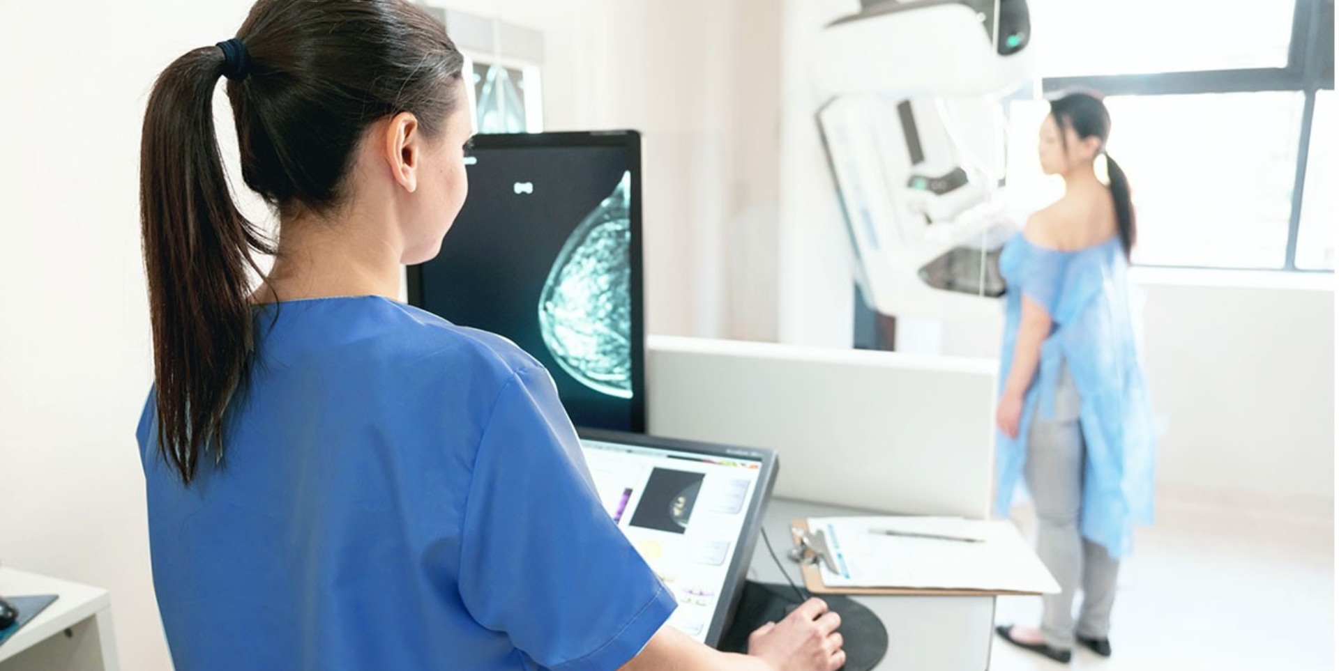 A radiographer takes a mammogram of a woman attending a special clinic