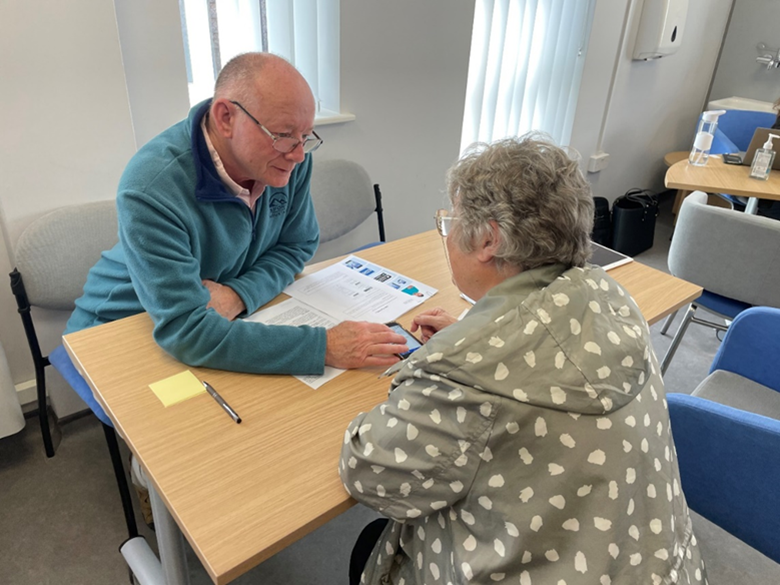 2 people looking at the NHS App on a tablet