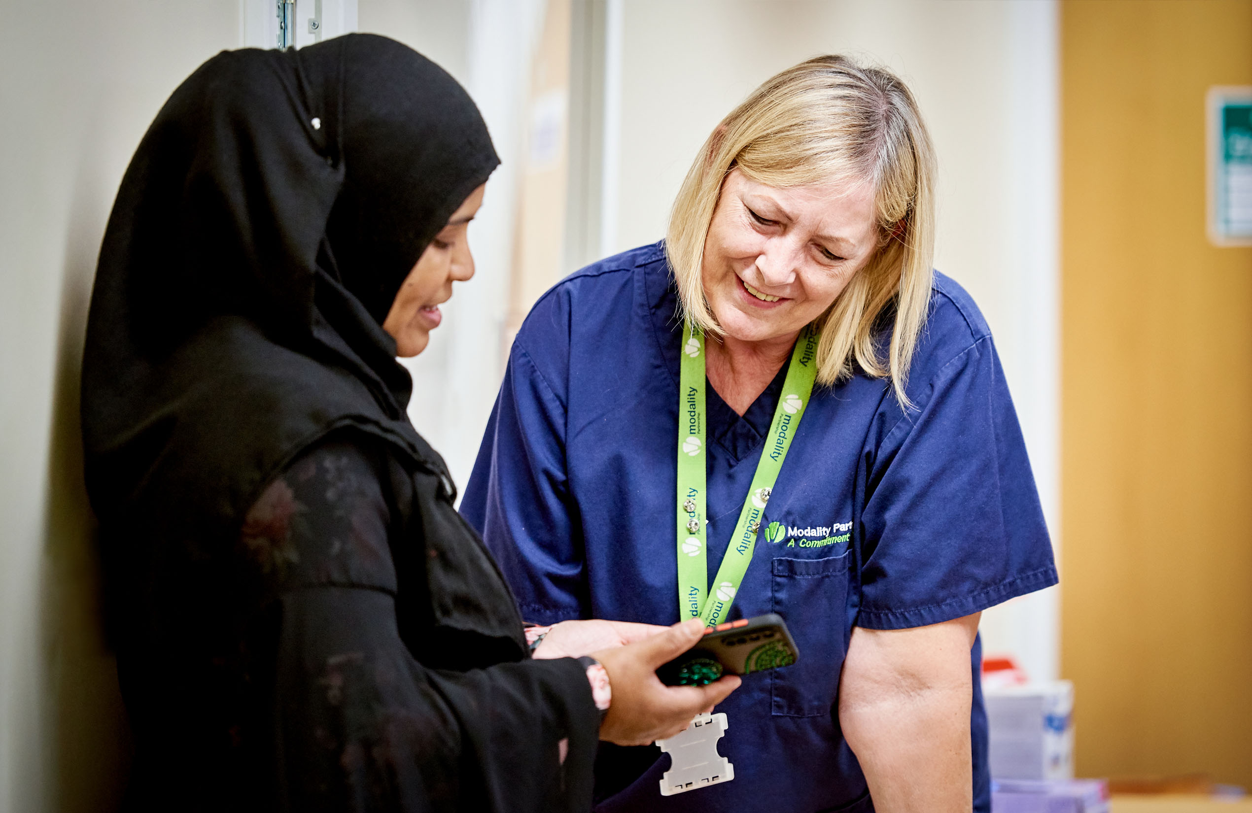 A member of staff at Holycroft surgery helping a patient register online