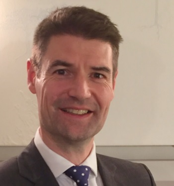 Head and shoulders of Dr Simon Eccles in a suit and tie