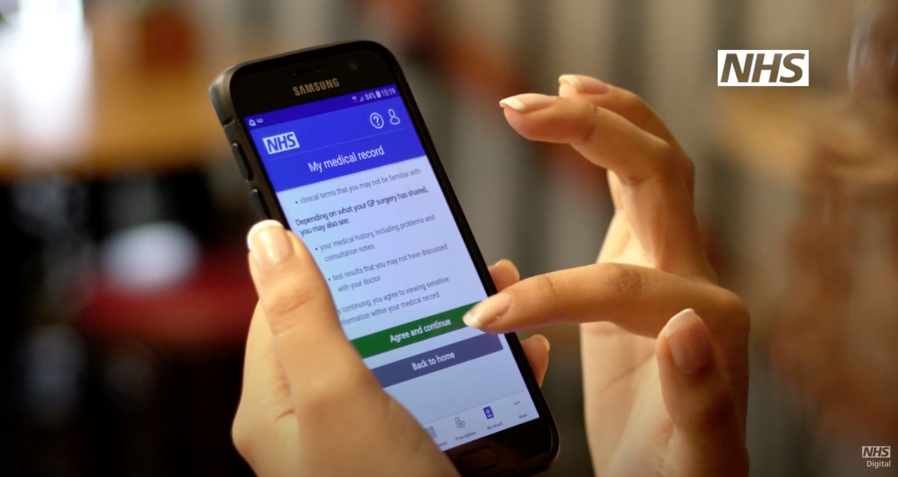image of hand holding phone which is displaying a NHS Login screen