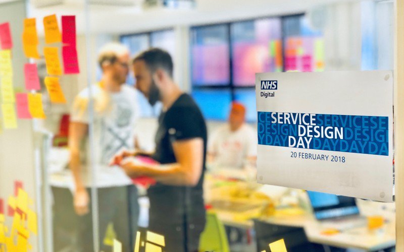 Service designers work behind a sign that reads NHS Digital Service Design Day
