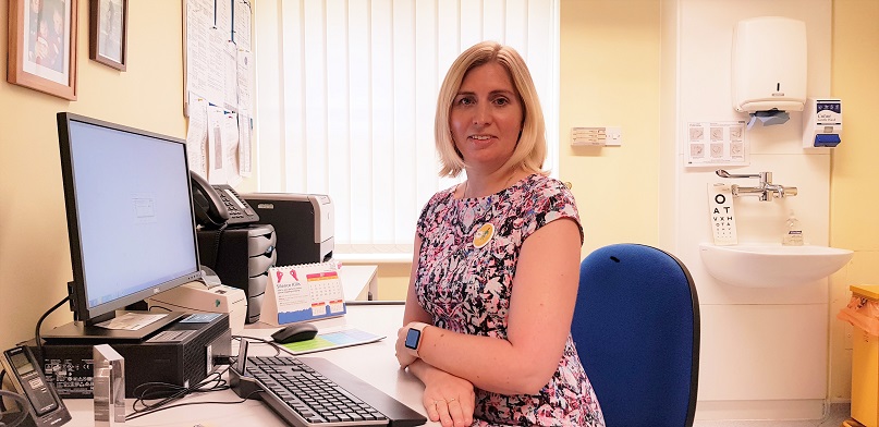GP Dr Kirsty Gillgrass sitting in her chair by her desk in her surgery room
